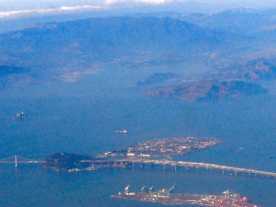 an overhead view of Treasure Island and the Bay Bridge from way above. In the background Angel Island and the North Bay are visible